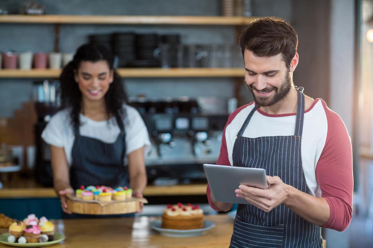 Mozrest - Restaurant manager responding to positive reviews online with a tablet - 5 Ways to Respond to Positive Reviews (Examples)