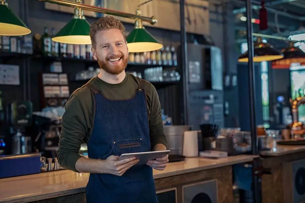 Mozrest - Smiling restaurant staff using a tablet