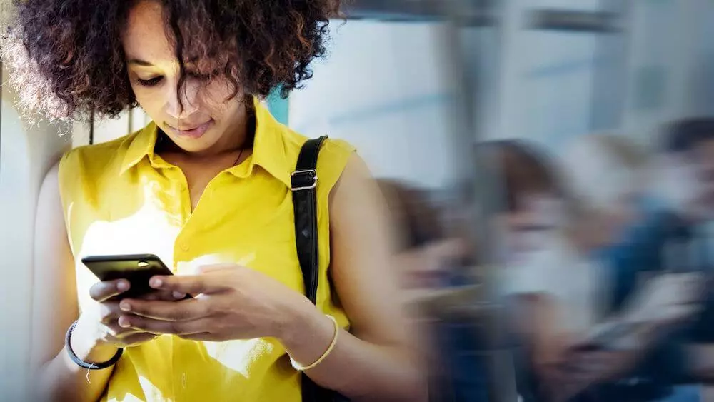 Mozrest - Woman in the tube booking a table in a restaurant online with her smartphone