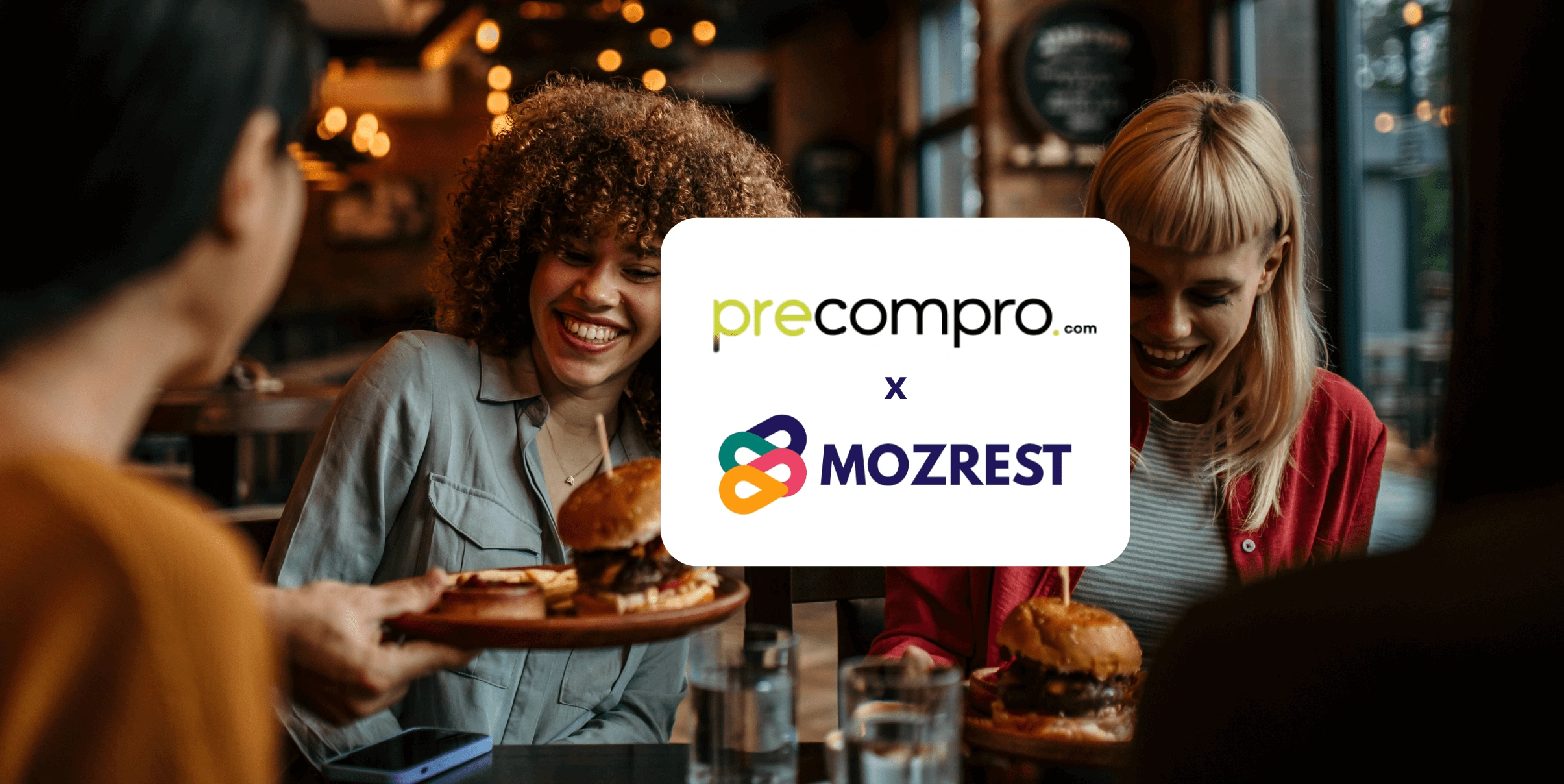 Mozrest - Solutions pour les Canaux de Réservation - Un groupe d'amis assis à une table dans un restaurant cherchant leur prochain endroit où manger sur leur téléphone mobile.
